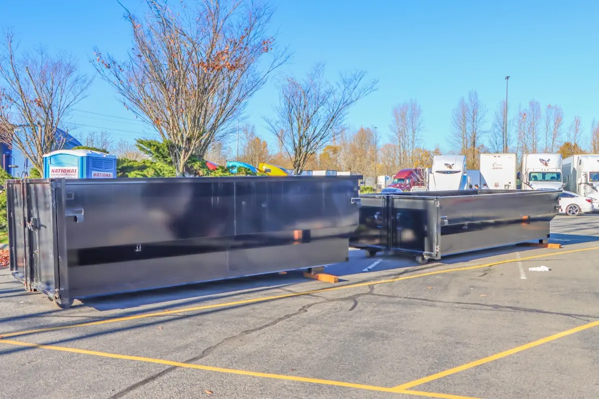 Professional dumpster rental service with roll-off container on residential driveway in Guilford